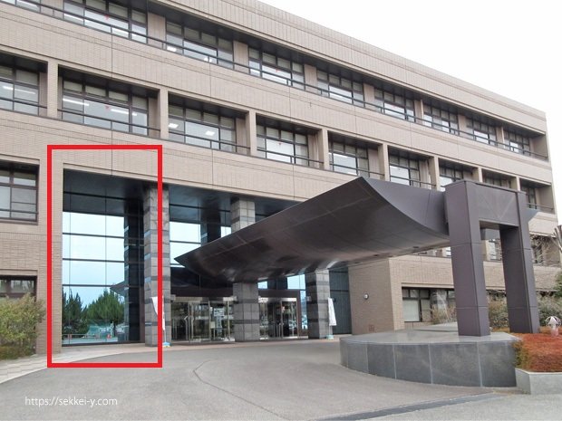 ガラスに写る吉野聡「山梨県北巨摩合同庁舎」