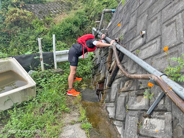 道路沿いの配管から水が流れています