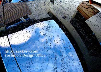 雨上がりのボンネットに写る自社の建築